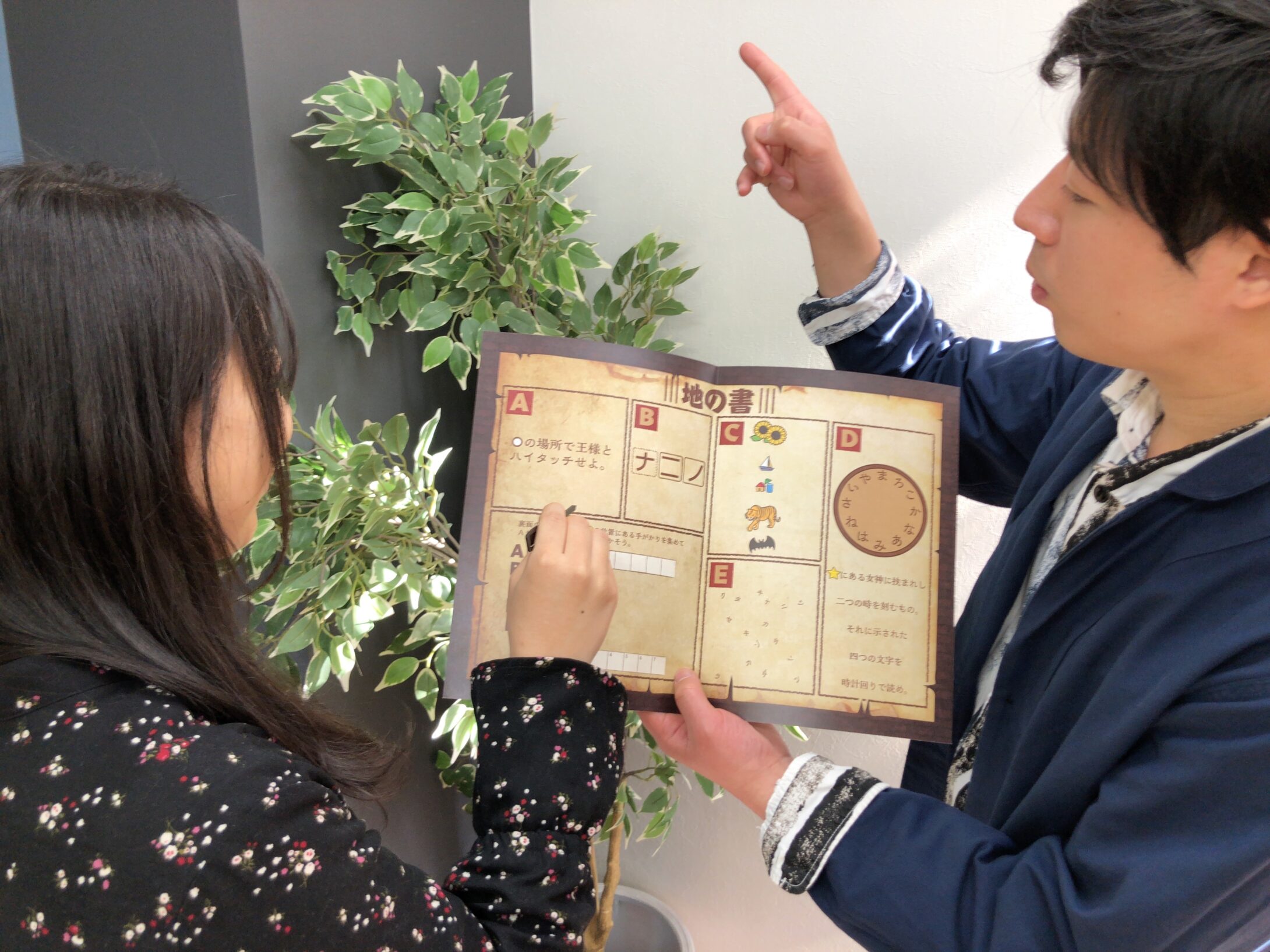 謎解き冊子を見ながら話し合う男女