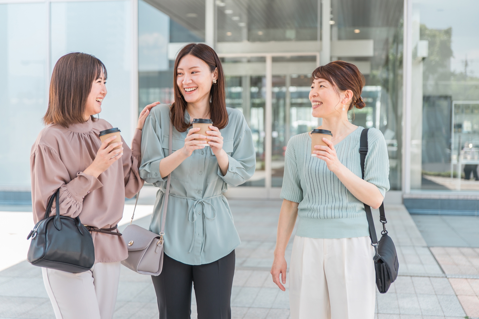コーヒーを持ちながら楽しそうに会話をする女性たち