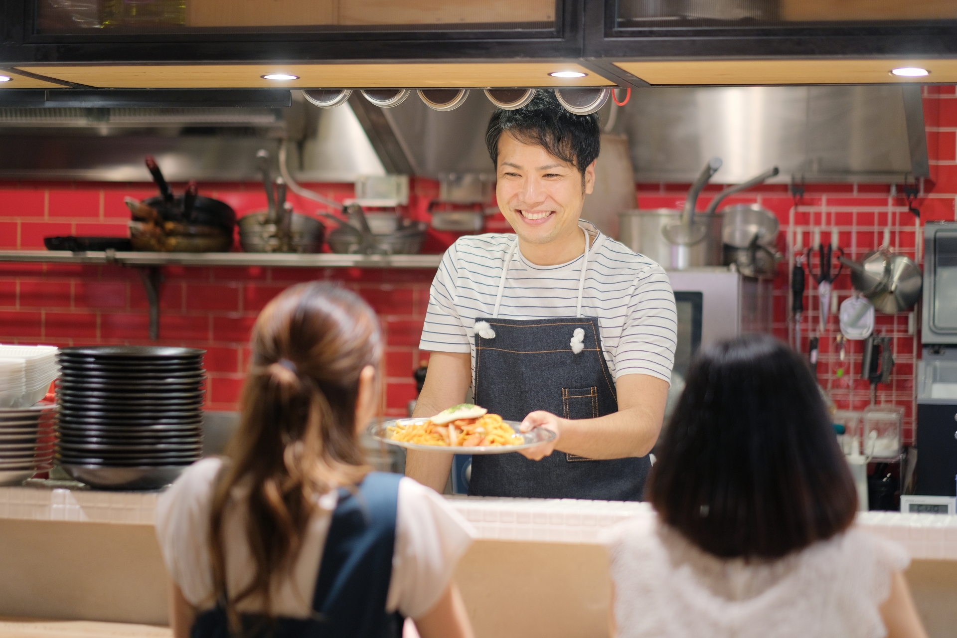 カフェの店主と会話をする女性たち